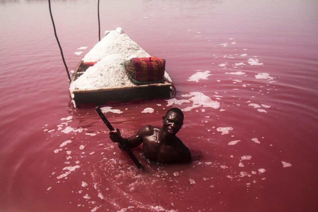 Hombre arrastrando una barca de sal en el Lago Rosa de Senegal