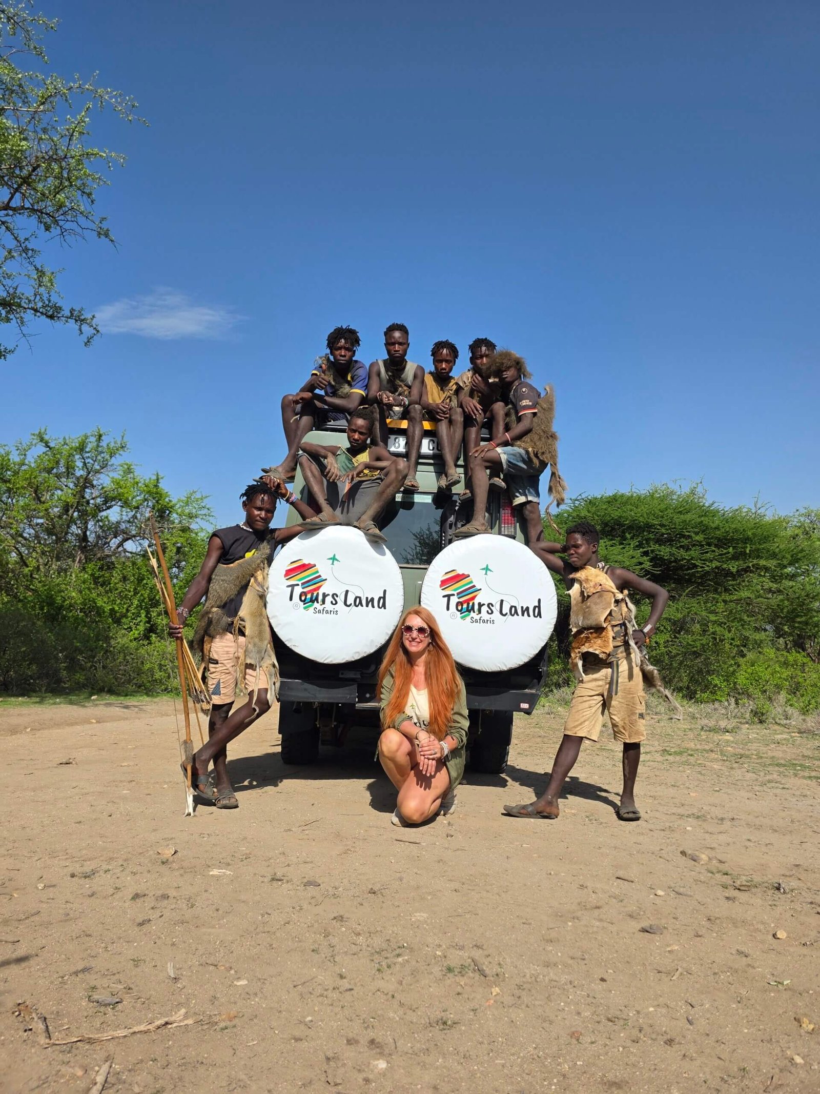 María de Tours Land Safaris junto a varios miembros de la tribu Hadzabe subidos al jeep durante safari en Tanzania